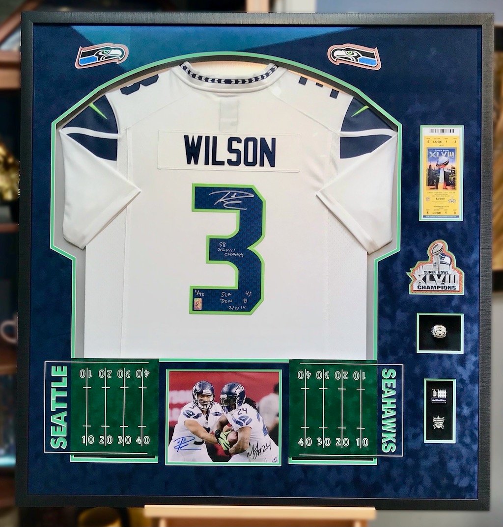 Russell Wilson Superbowl Signed Jersey Framed with SB Tickets, Patch, Pins and Superbowl Ring, plus our signature Football field